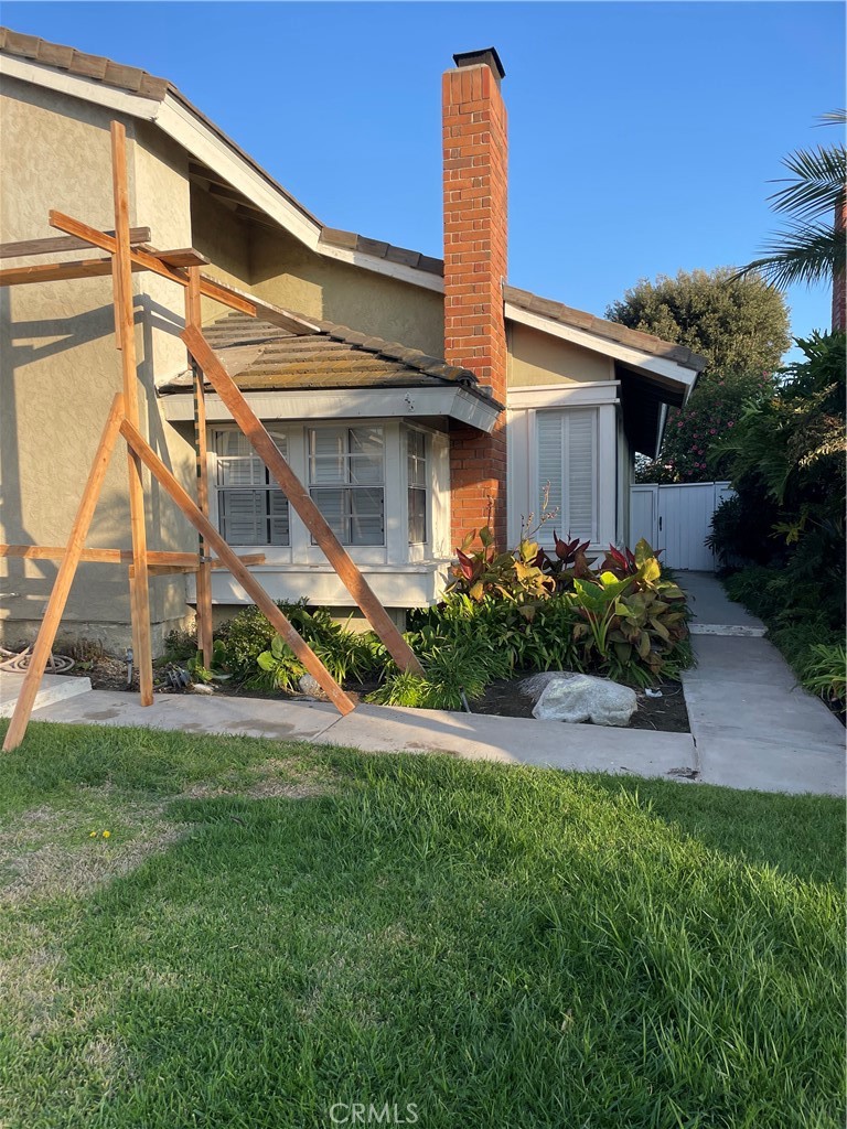 a front view of a house with a yard and potted plants