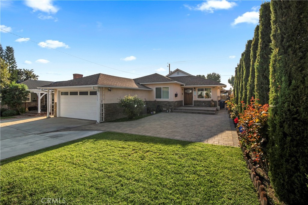 a front view of a house with a yard and trees