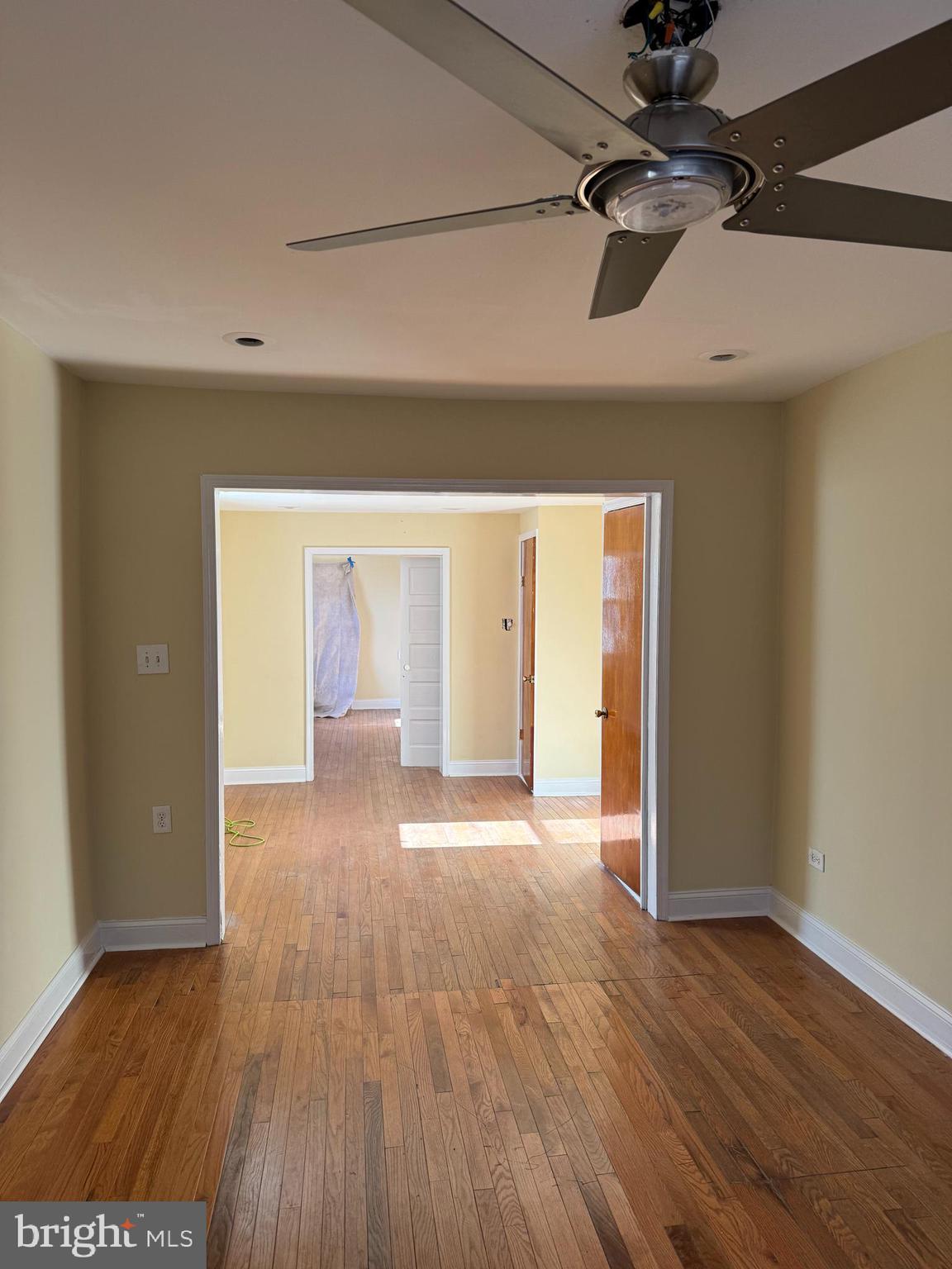 a view of an empty room with wooden floor