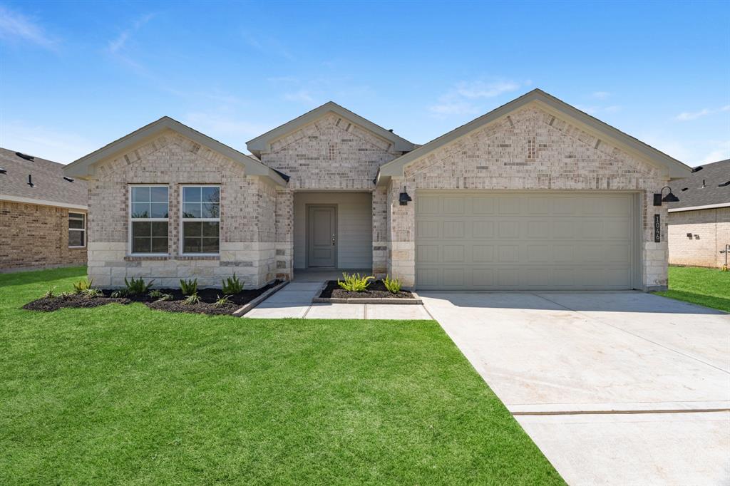 a front view of a house with a yard and garage