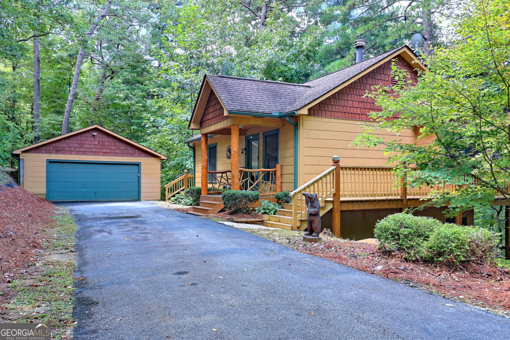 a view of a house with a yard and large tree