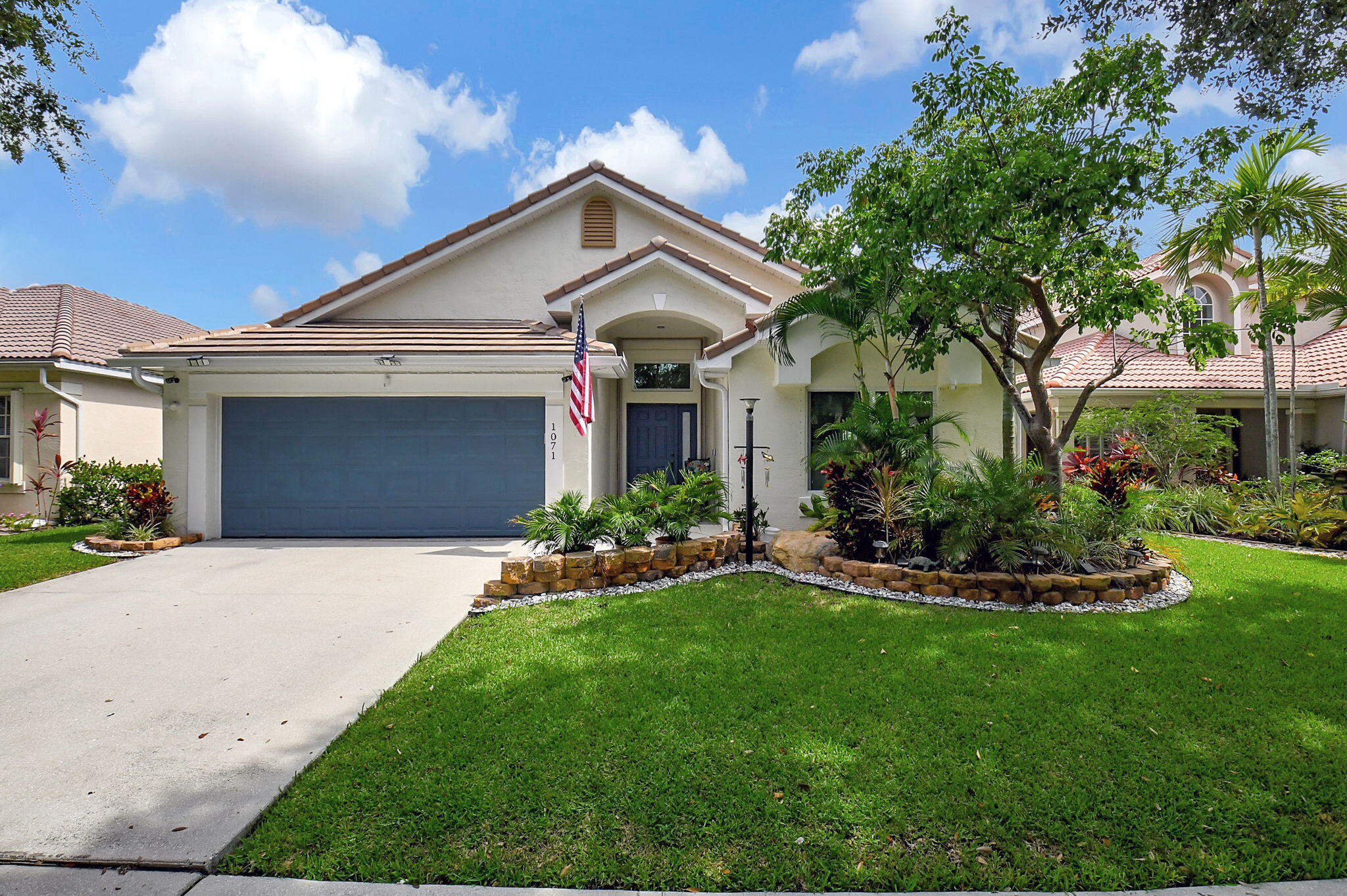 a front view of a house with a garden and yard