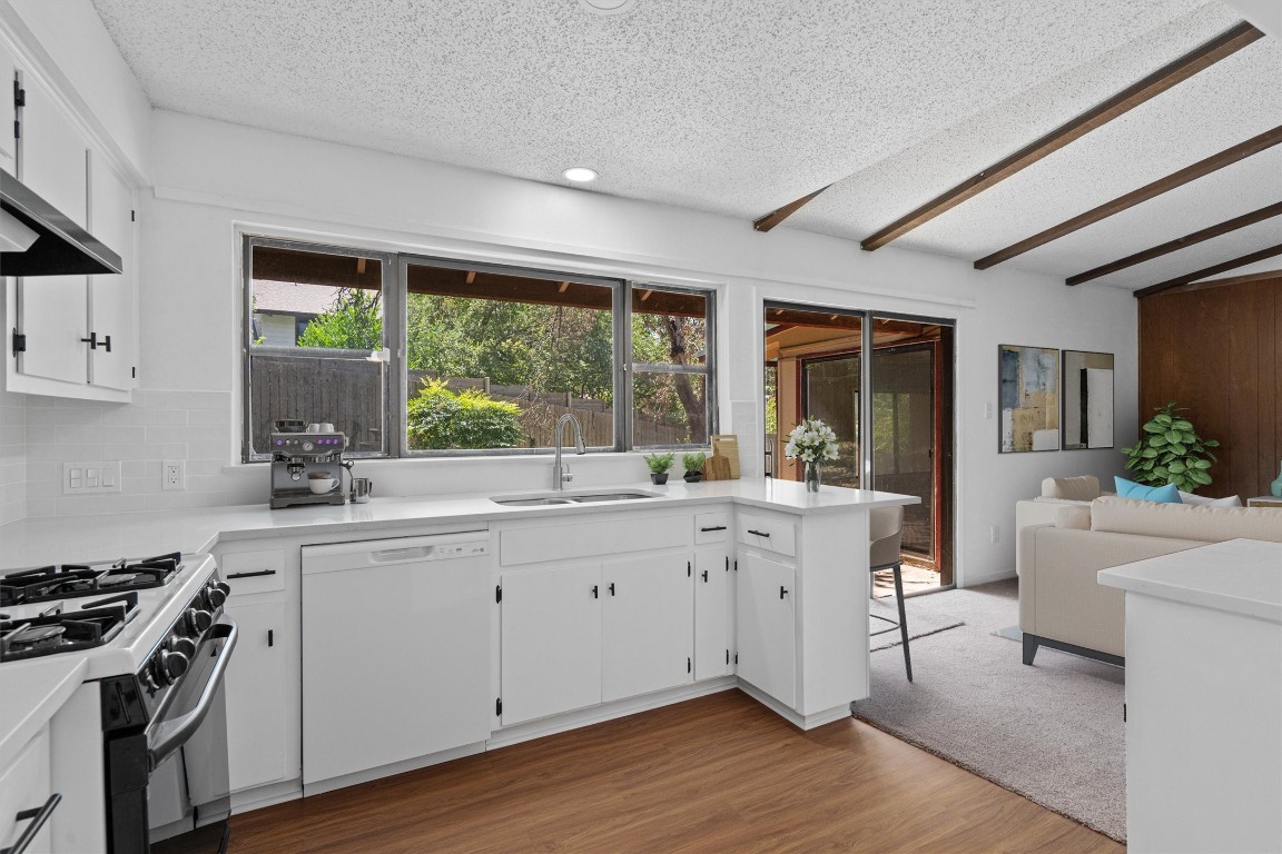 a kitchen with sink stove and white cabinets