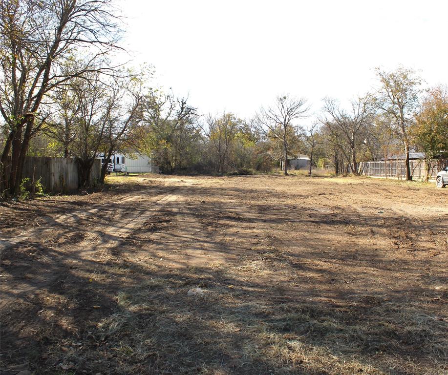 a big yard with trees in the background