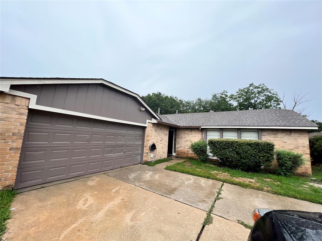 This is a single-story home with a large garage, traditional brick facade, and a well-sized front yard.