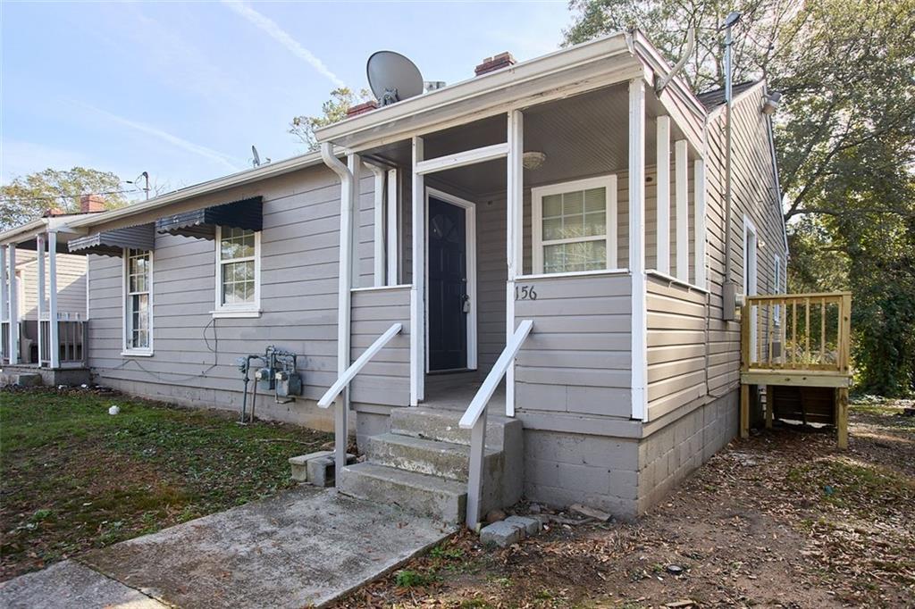 a view of a house with backyard and chairs