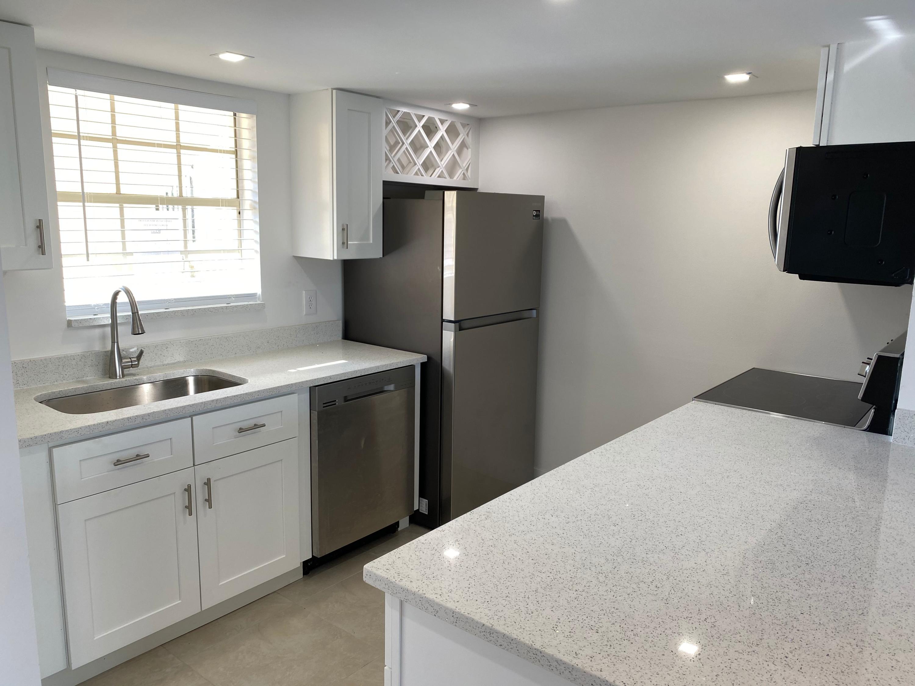 a kitchen with a refrigerator sink and cabinets