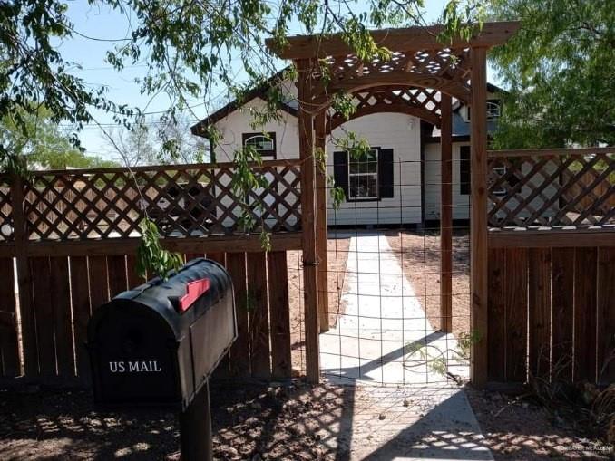 a view of a house with a large tree and wooden fence