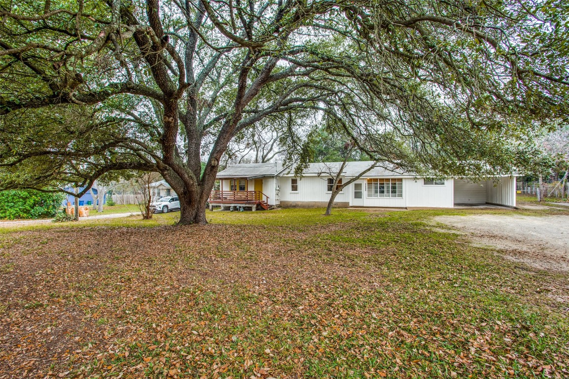 a front view of a house with a garden and trees