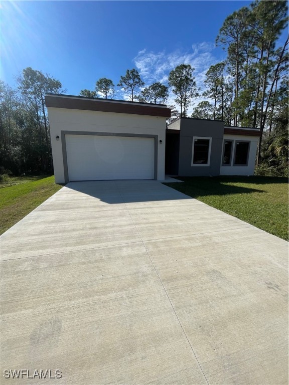 a front view of house with yard and trees in the background