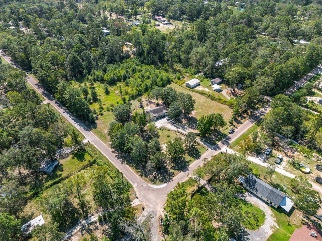 an aerial view of residential houses with outdoor space and trees