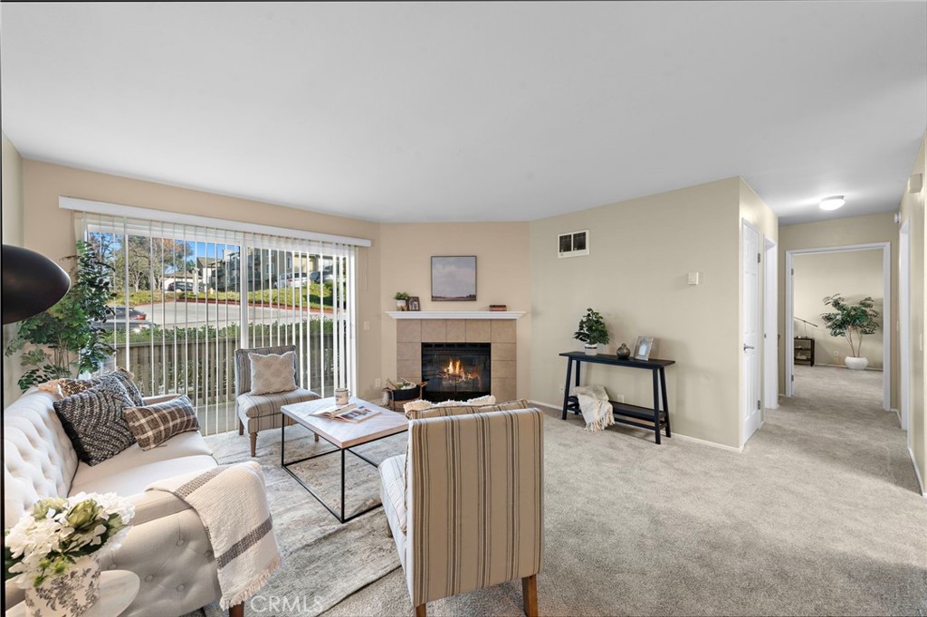 a living room with furniture a fireplace and a floor to ceiling window