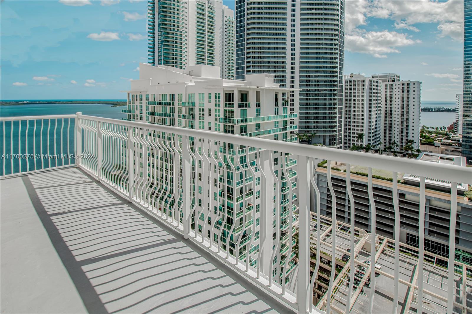 a view of a balcony with wooden floor and fence