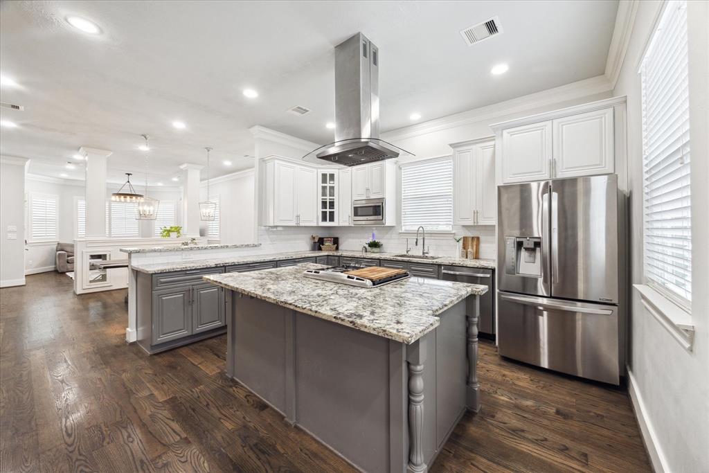 A chef's dream kitchen featuring top-of-the-line stainless steel appliances and a large granite island.