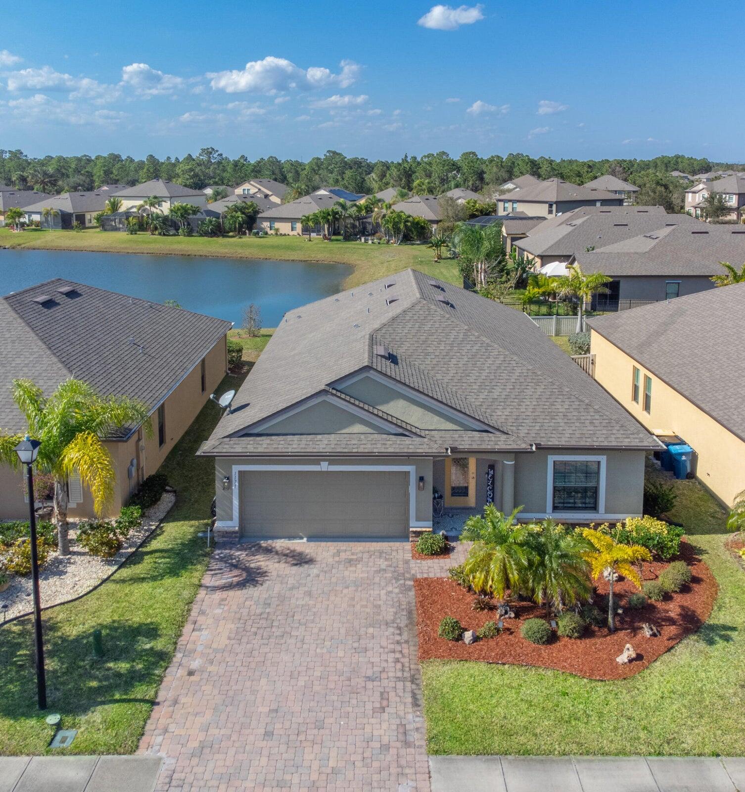 a front view of a house with a garden and lake view