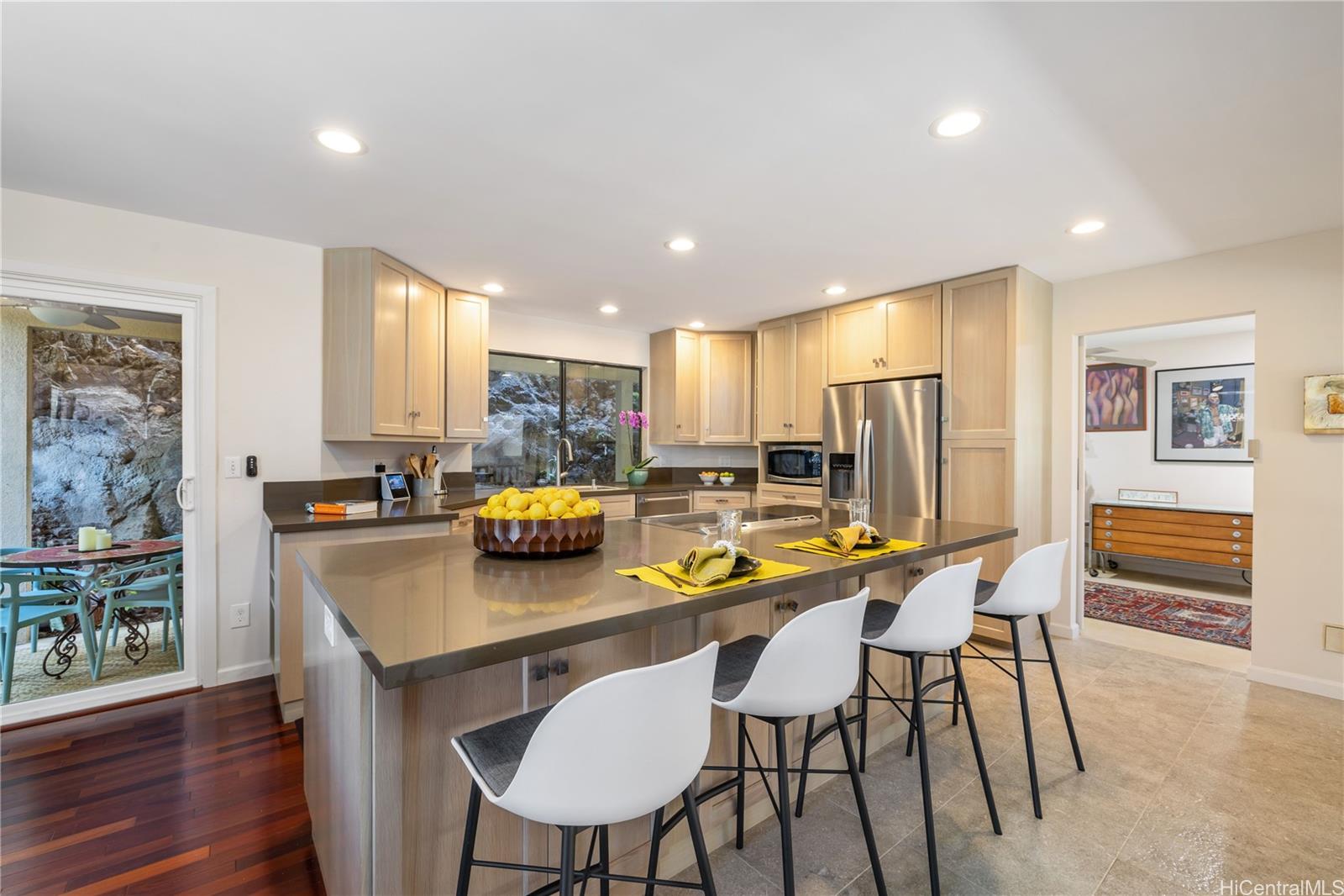 a kitchen with stainless steel appliances a dining table chairs and refrigerator