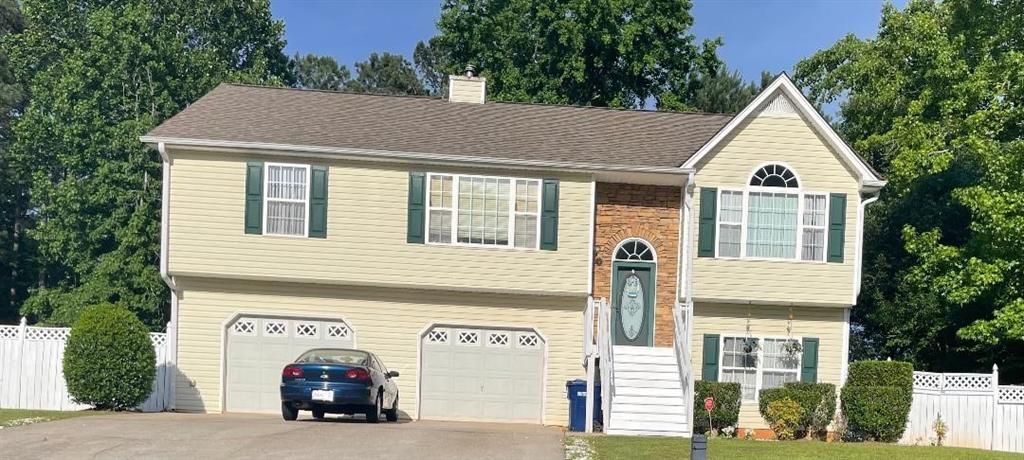 a view of a house with a car park side of road