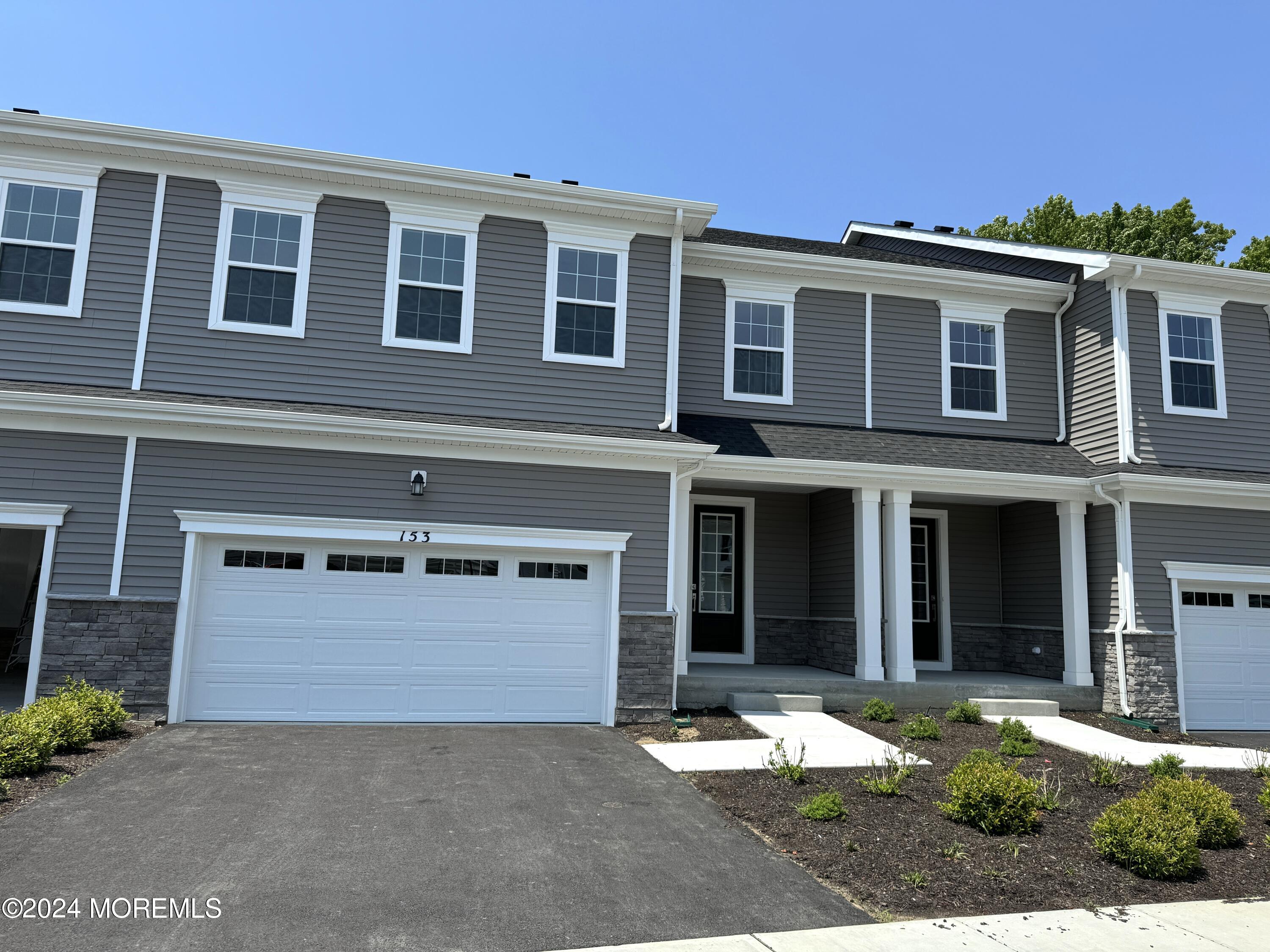 a front view of a house with yard and parking space