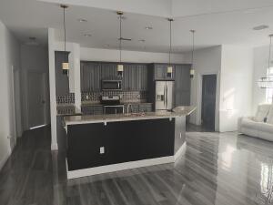 a kitchen with kitchen island stainless steel appliances a sink stove and refrigerator