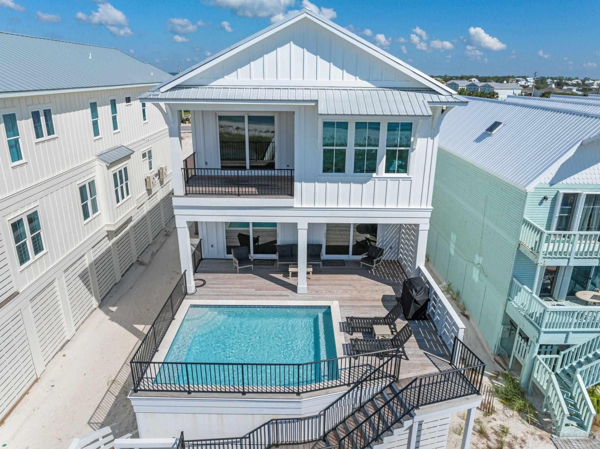 a view of a house with pool and sitting area