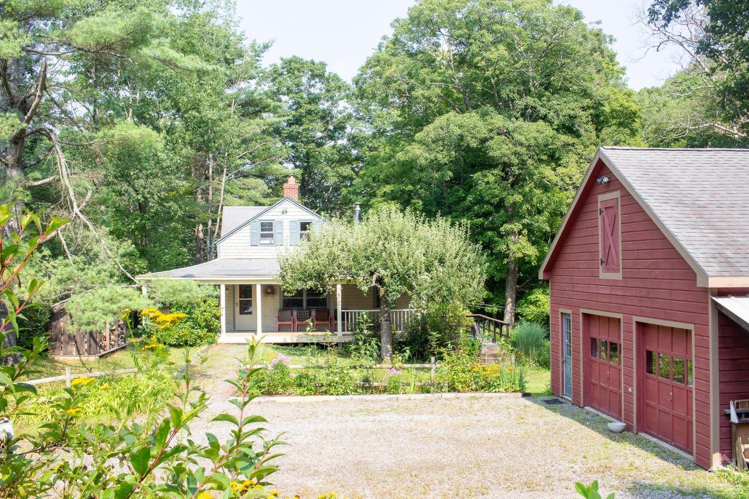 a view of house with a yard and potted plants