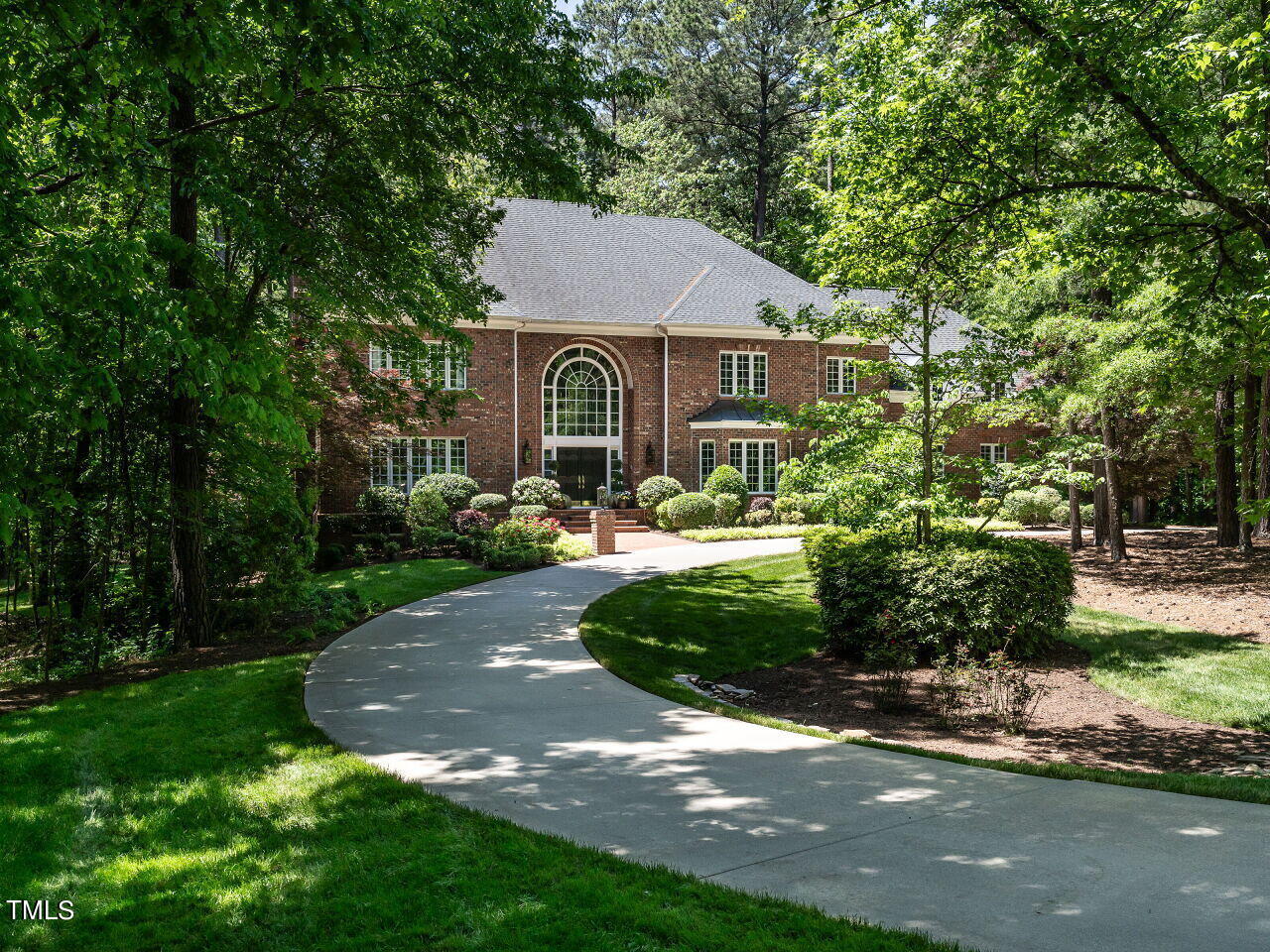 a front view of a house with a yard and a garden