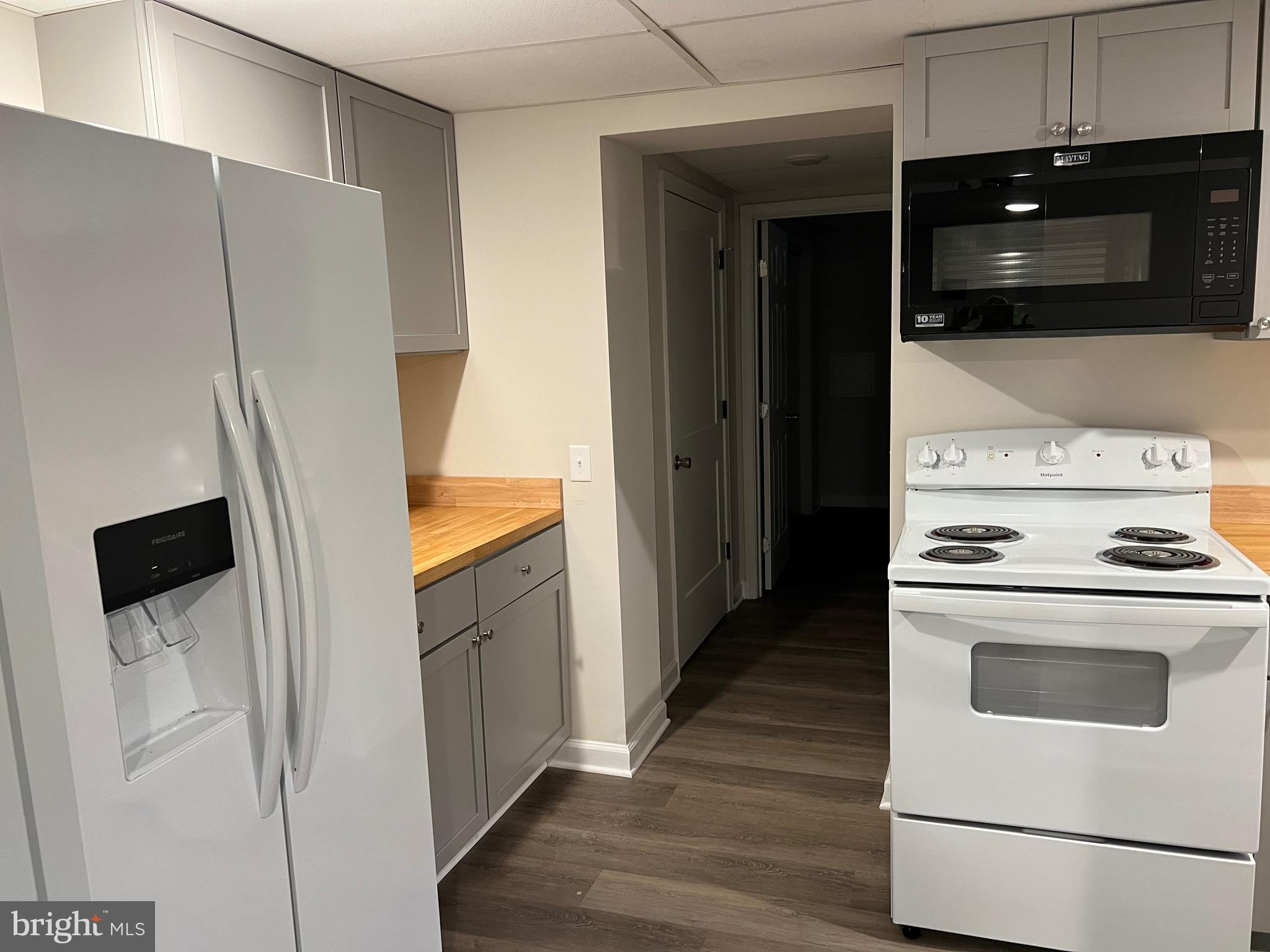 a kitchen with a refrigerator stove and white cabinets