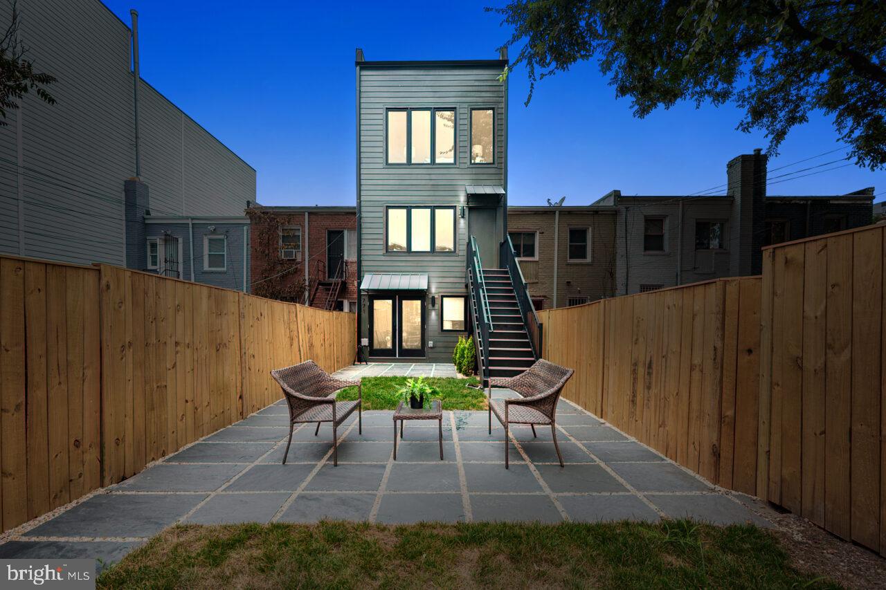 a backyard of a house with table and chairs