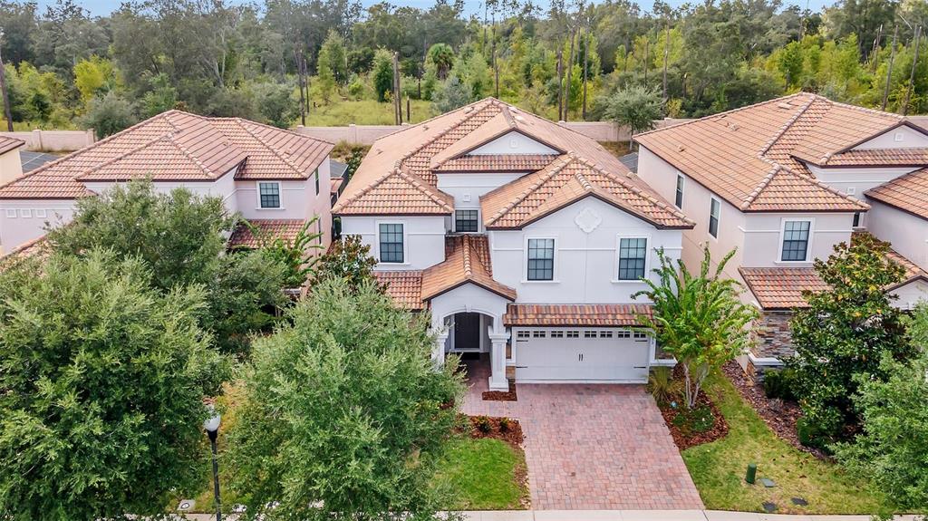 a aerial view of a house with a yard and large tree