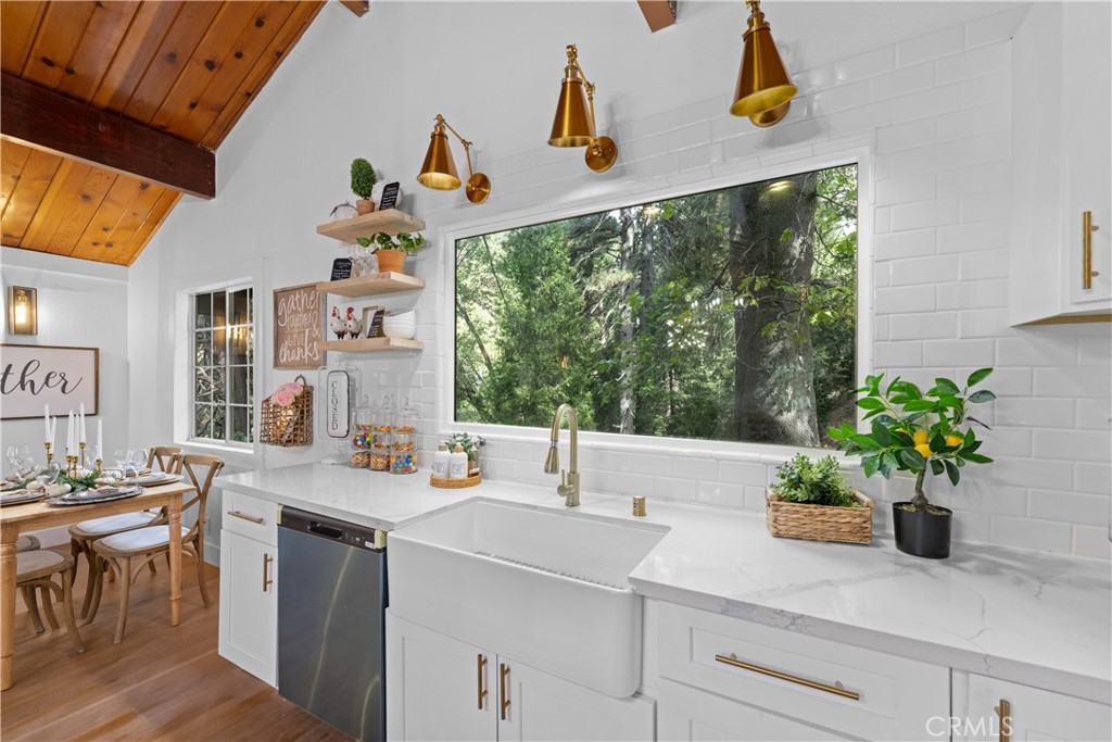 a kitchen with a sink a counter and a living room view