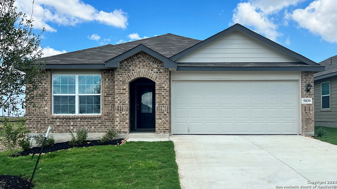 a front view of a house with a garden and yard