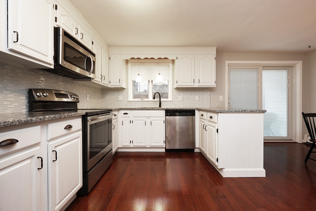 a kitchen with stainless steel appliances a white stove top oven sink and cabinets