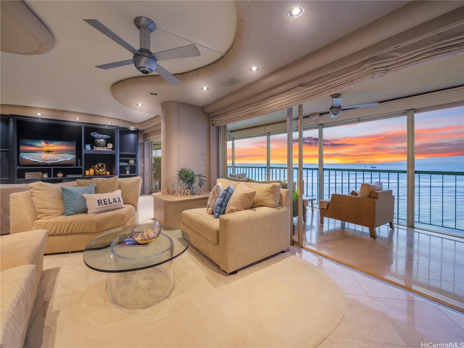 a living room with furniture a ceiling fan and a large window