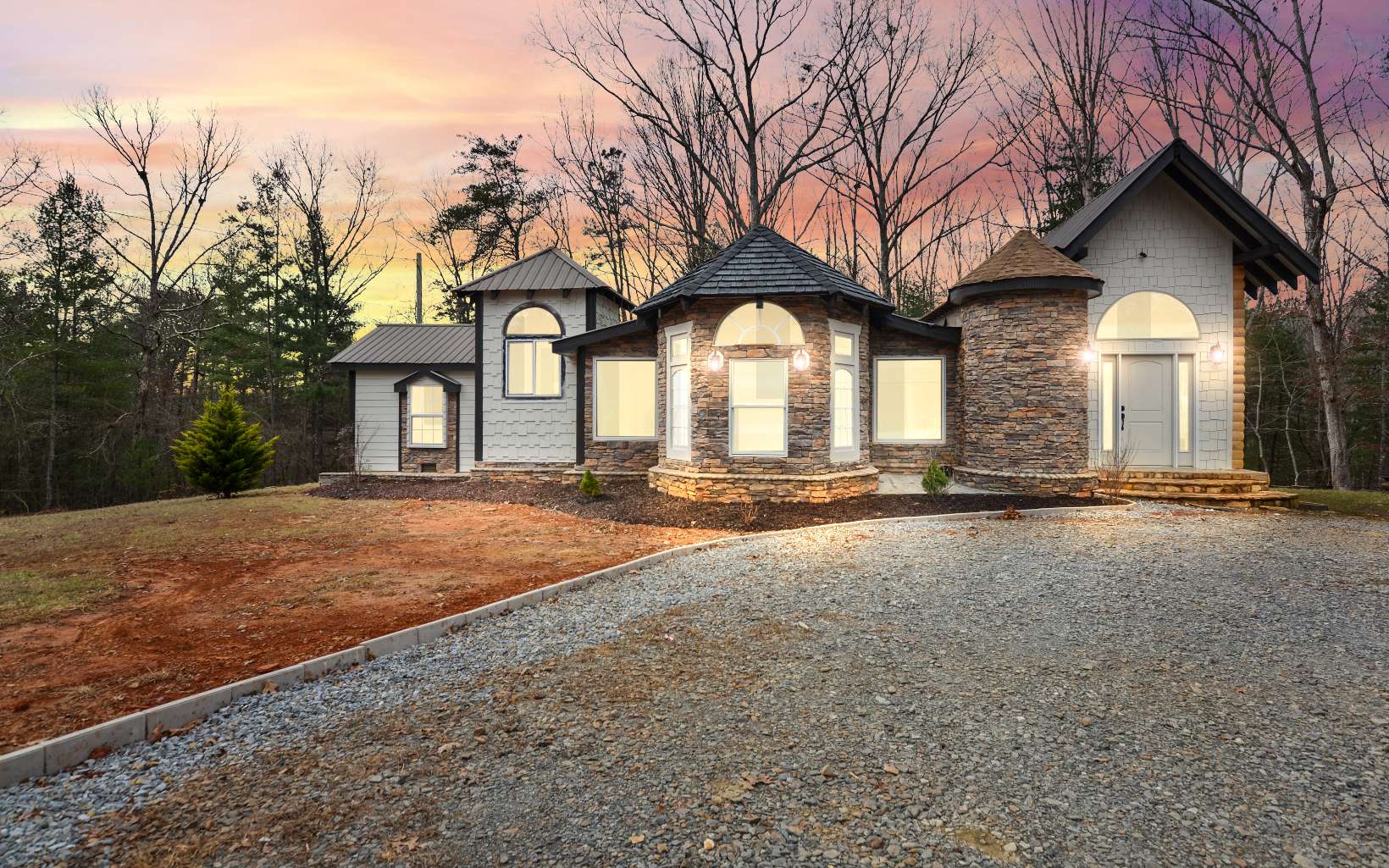 a front view of a house with yard and trees