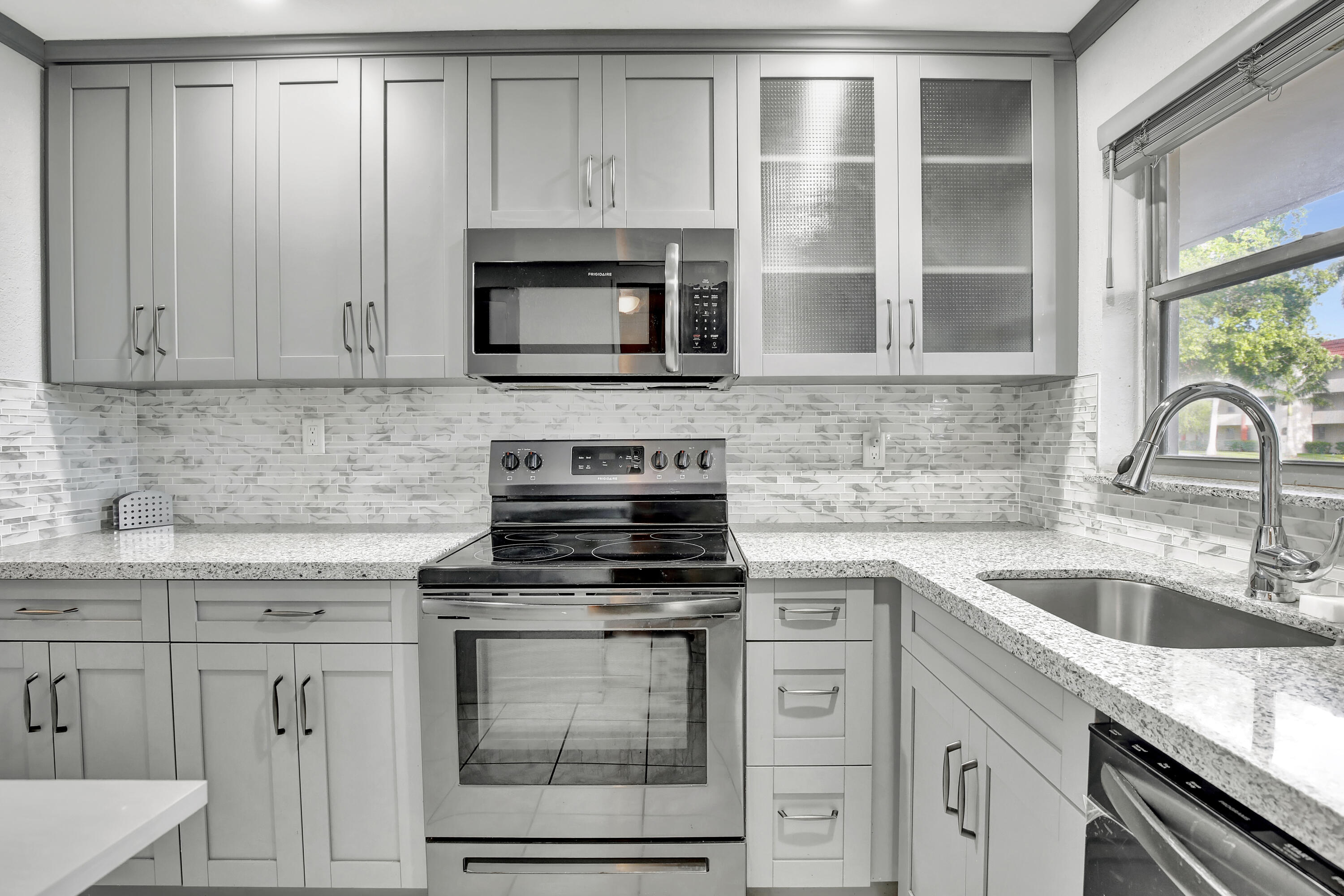 a kitchen with cabinets stainless steel appliances and a sink