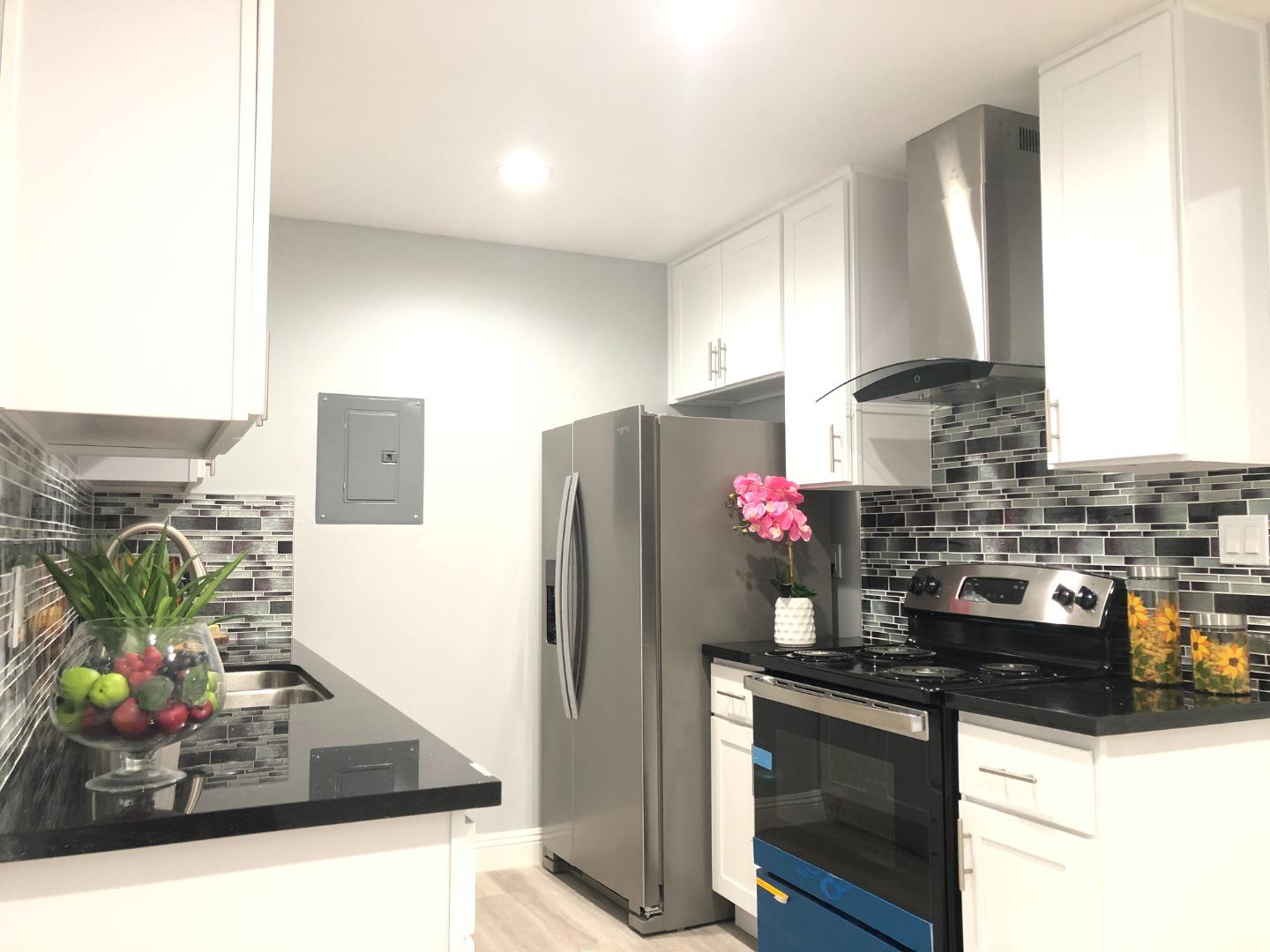 a kitchen with stainless steel appliances granite countertop a sink dishwasher and a refrigerator