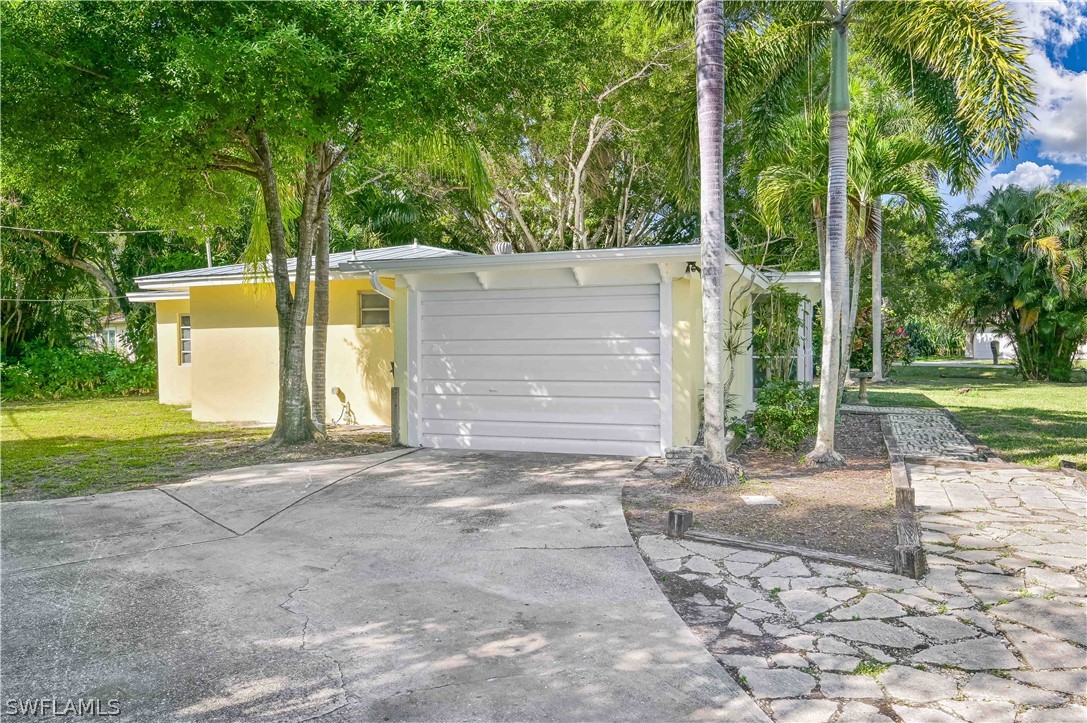 a view of a house with backyard and a tree