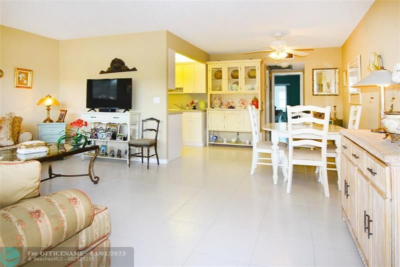 a living room with furniture a flat screen tv and a dining table