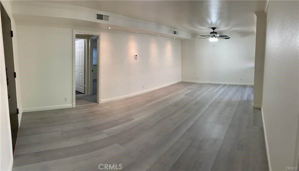 a view of an empty room with wooden floor