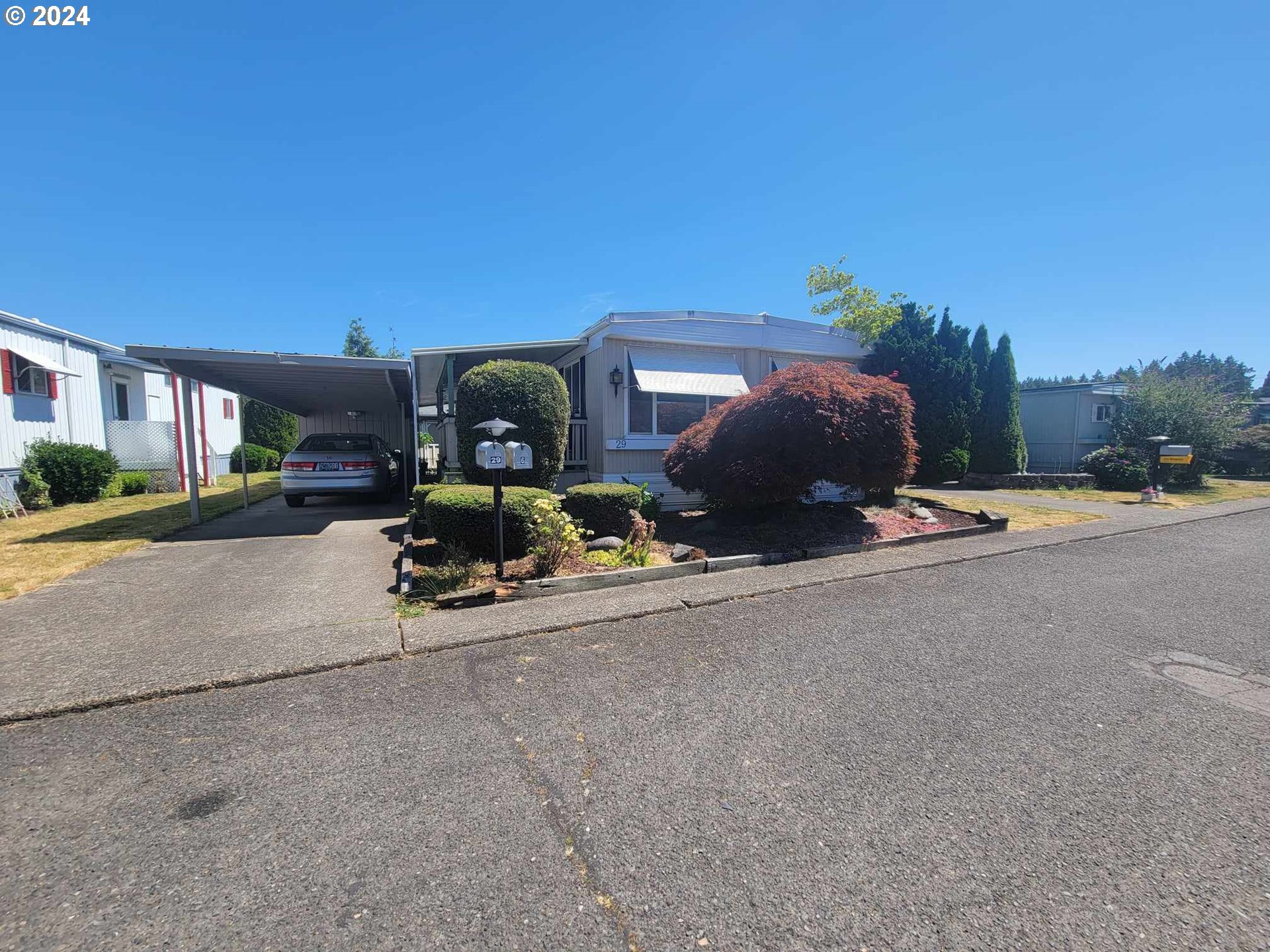 a front view of a house with a yard and a car parked