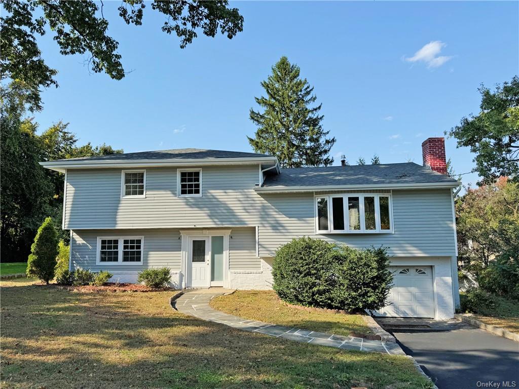 Tri-level home with a garage and a front yard