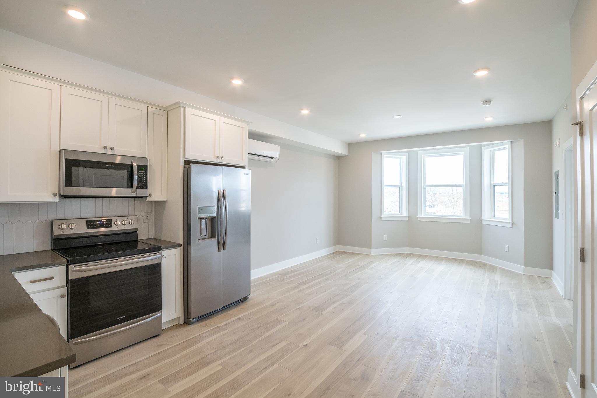 a view of kitchen with wooden floor electronic appliances and window