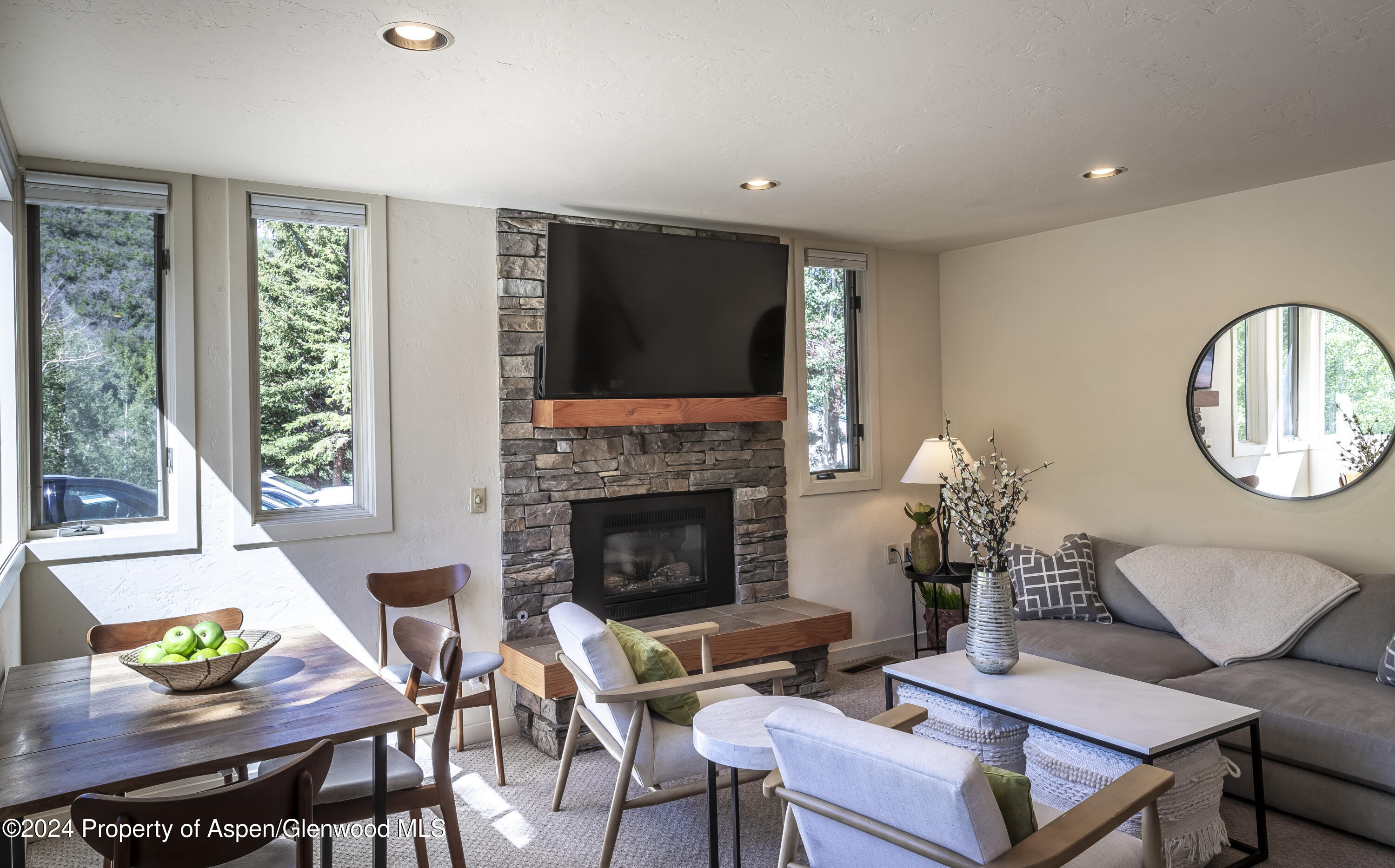 a living room with furniture a large window and a fireplace