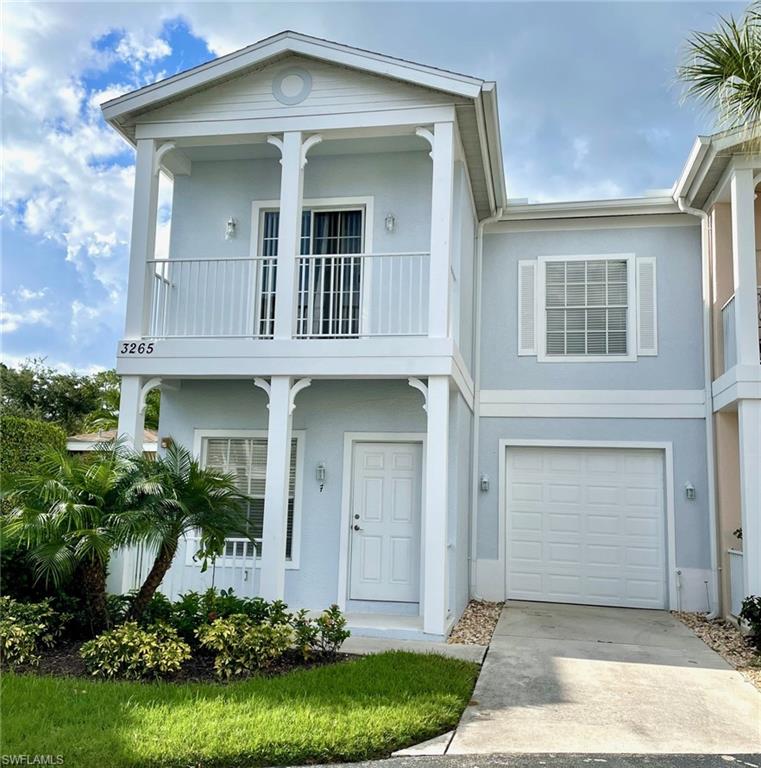 View of front of property with a balcony and a garage