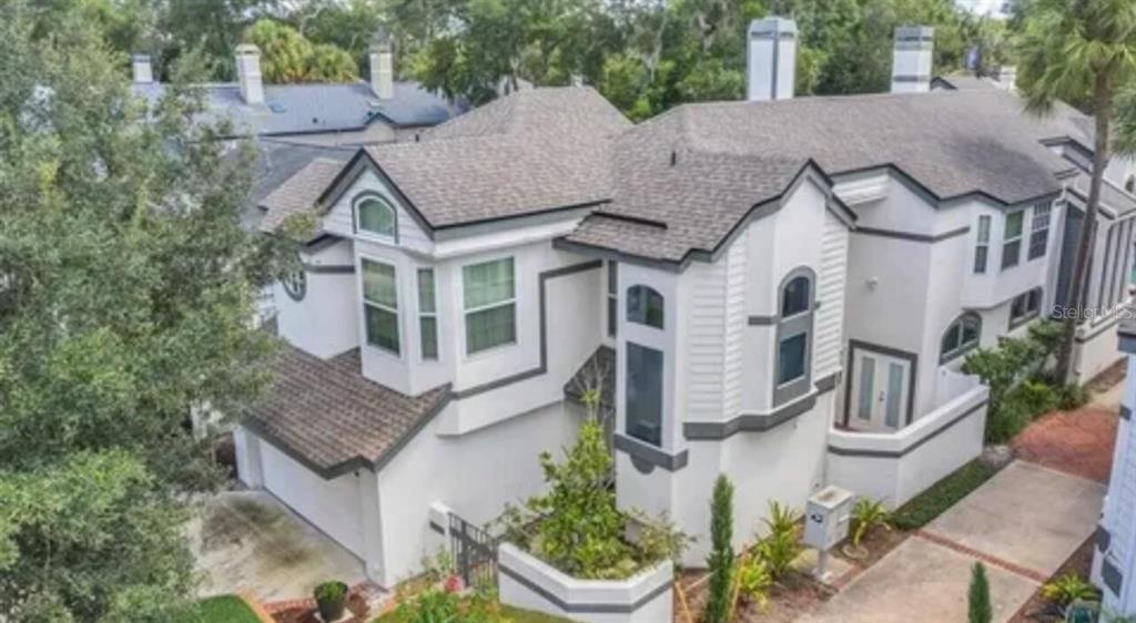 a aerial view of a house with a yard and potted plants