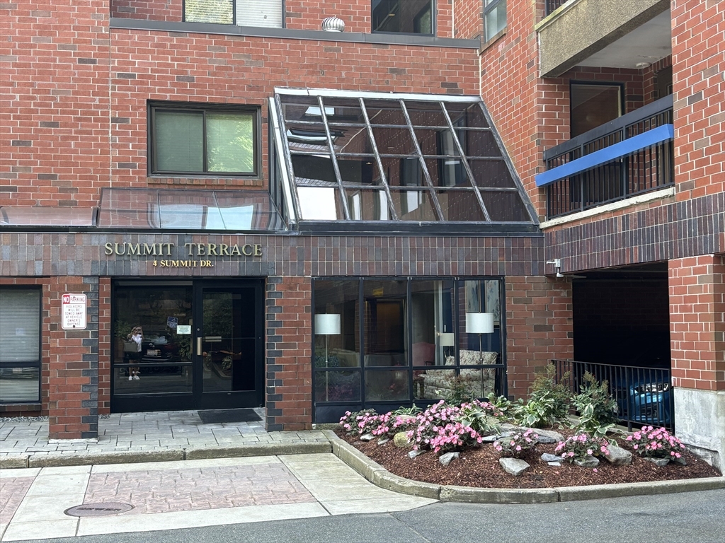 a view of a brick building with potted plants