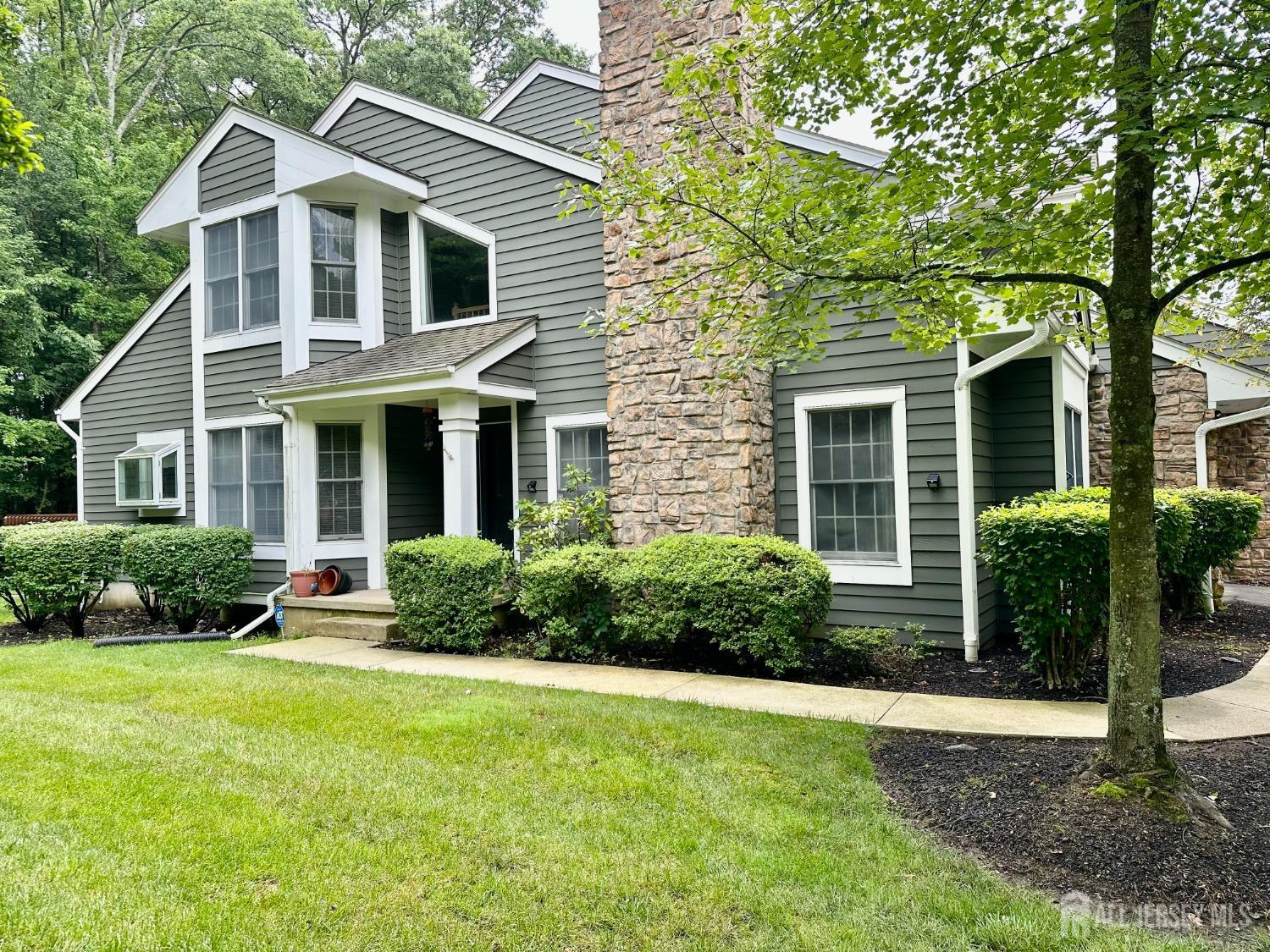 a front view of a house with a yard and plants