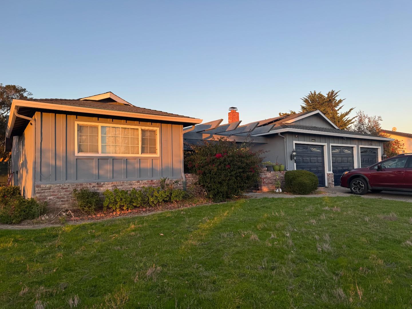 a front view of a house with a garden and plants