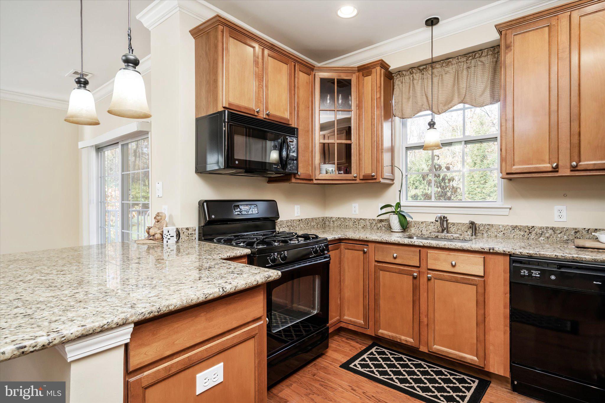 a kitchen with stainless steel appliances granite countertop a stove sink and microwave