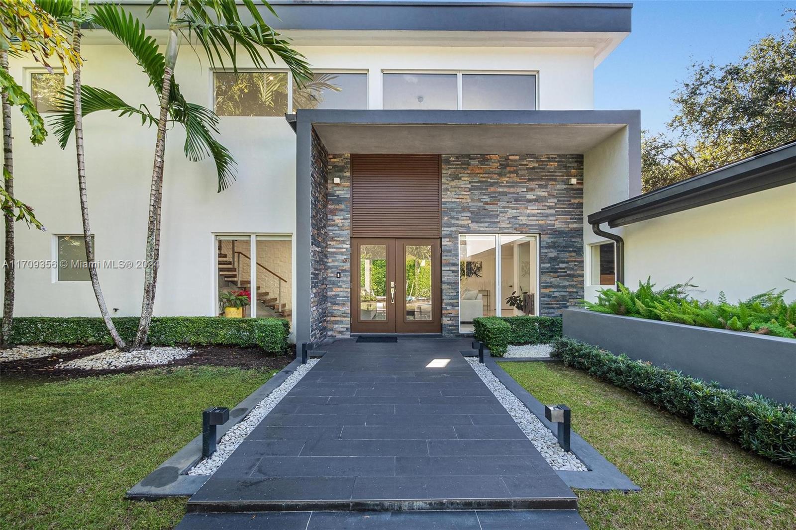 a front view of a house with a yard and outdoor seating